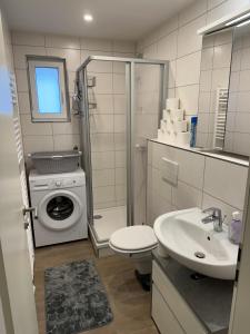 ein Badezimmer mit einer Waschmaschine und einem Waschbecken in der Unterkunft Villarina in Dresden