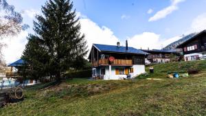 a house on top of a hill with a tree at Chalet Independent, Termen in Termen