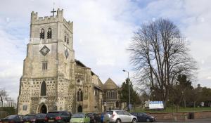 an old church with cars parked in front of it at Rhapsody Premium in Waltham Abbey