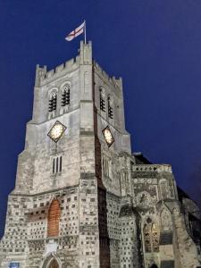 a clock tower with a flag on top of it at Rhapsody Premium in Waltham Abbey