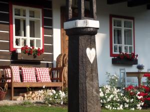 a pole with a heart painted on it in front of a house at Penzion Roubenka in Hukvaldy