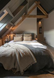 um quarto com uma cama grande num sótão em Erve Jonkerhoeve em Heesch