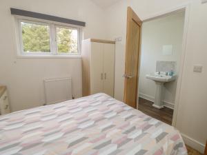 um quarto com uma cama, um lavatório e uma janela em Wharfdale Pod em Yarm