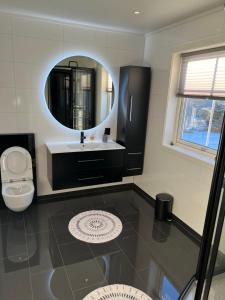ein Bad mit einem Waschbecken und einem Spiegel in der Unterkunft Villaveien in Sortland