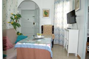 a living room with a table and a tv at Apartamento San Juan de Dios in Seville