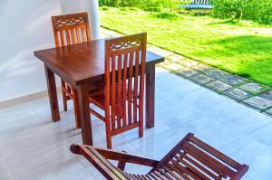 a wooden table and chairs on a patio at Dawn View Home Stay in Ella