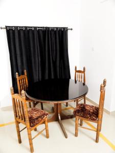 a table and two chairs and a curtain at The Chill House in Cochin