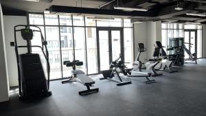a gym with a bunch of treadms and cardio machines at Al Raha lofts 1 in Al Qurayyah