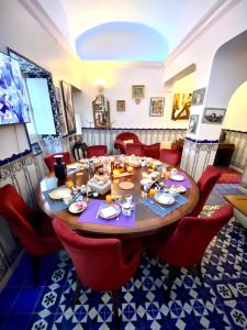 a dining room with a table and red chairs at Zenit Olhao Bed & Breakfast in Olhão