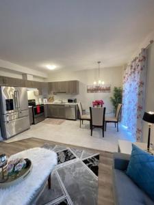 uma cozinha e sala de estar com mesa e cadeiras em Holiday_Comfort em Cataratas do Niágara