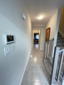um corredor com escadas e uma televisão na parede em Holiday_Comfort em Cataratas do Niágara