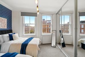 sypialnia z 2 łóżkami i lustrem w obiekcie Delightful Flat in London - Sleeps 6 w Londynie