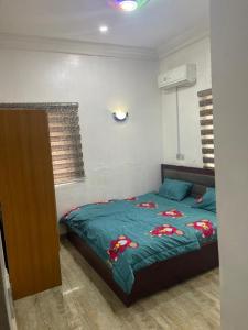 Galadima的住宿－Adriel Homes，一间卧室配有一张带绿色棉被的床