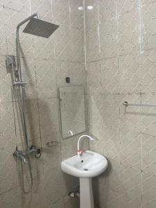 Galadima的住宿－Adriel Homes，浴室配有盥洗盆和带镜子的淋浴
