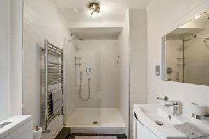 a white bathroom with a shower and a sink at Delightful Flat in London - Sleeps 6 in London