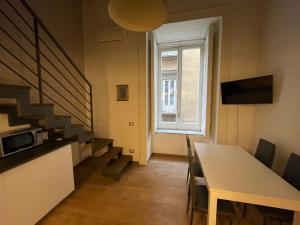een woonkamer met een trap, een tafel en een raam bij Suite Della Porta in Napels