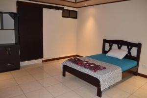 um pequeno quarto com uma cama e um armário em SERENITY HOME H Y M em Turrialba