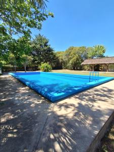 a large blue swimming pool with a playground at Complejo Tiú Mayú in La Granja