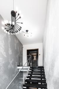 un pasillo con escaleras y una lámpara de araña en Geography, en Veresneve