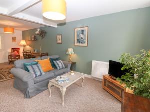 a living room with a couch and a tv at The Bell Apartment in Cemaes Bay