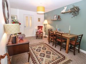 a dining room and living room with a table and chairs at The Bell Apartment in Cemaes Bay
