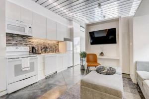 a kitchen with white cabinets and a couch and a tv at KCM Tremont Oaks Apartments 7 in Cleveland