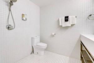 a white bathroom with a toilet and a shower at KCM Tremont Oaks Apartments 7 in Cleveland