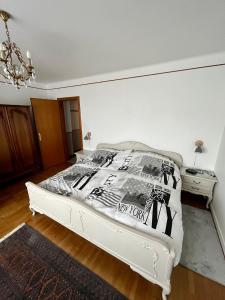 a bedroom with a white bed and a dresser at Townhouse - Strasbourg Robertsau in Strasbourg