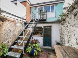 a house with a staircase leading up to a door at The Bell Apartment in Cemaes Bay