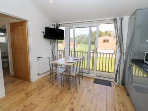 a dining room with a table and a balcony at Nidderdale Pod in Yarm