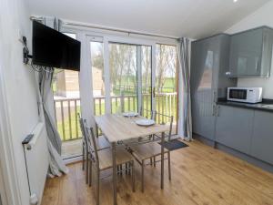 a kitchen and dining room with a table and a balcony at Nidderdale Pod in Yarm