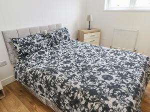 a bedroom with a bed with a black and white blanket at Glendale Pod in Yarm