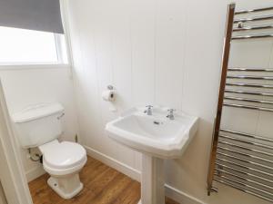 a white bathroom with a toilet and a sink at Glendale Pod in Yarm