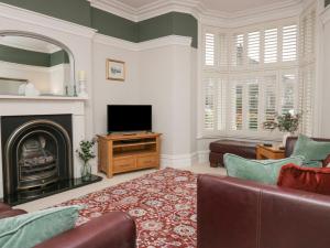 a living room with a couch and a television at Heatherlea in Keswick