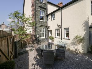 a patio with a table and chairs in front of a building at Heatherlea in Keswick