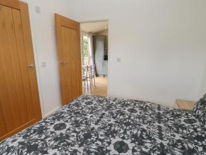 a bedroom with a bed with a black and white blanket at Wensleydale Pod in Yarm