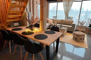 salon z drewnianym stołem i krzesłami w obiekcie Villa Pohjoistuuli - 5+1 henkilölle, Luoteis-Himos Ski-in/out 56m² + 11m² w mieście Jämsä