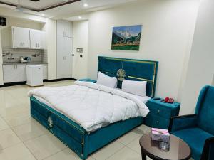 WE hotels Islamabad في اسلام اباد: غرفة نوم بسرير ازرق كبير وطاولة