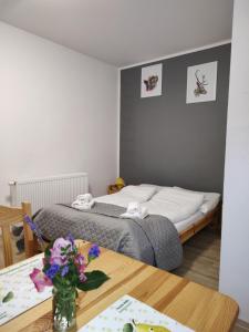 a room with two beds and a table with flowers at Pokoje Pod Gruszą -osobne wejścia in Kudowa-Zdrój