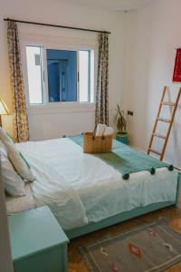 een bed in een kamer met een raam en een ladder bij Dar Sultana Guesthouse Surf Morocco in Tamraght Ou Fella