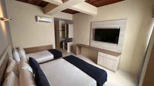 Habitación con TV, sofá y cama. en On Vacation Caribbean, en San Andrés