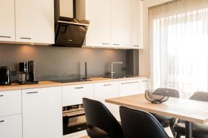 a kitchen with white cabinets and a table with chairs at Boardinghouse Hense in Lingen