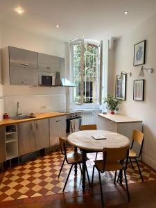 a kitchen with a table and a table and chairs at Kak's apartments Paris in Paris