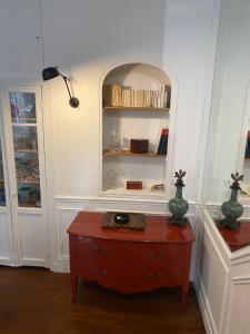a room with a table and a shelf with books at Kak's apartments Paris in Paris