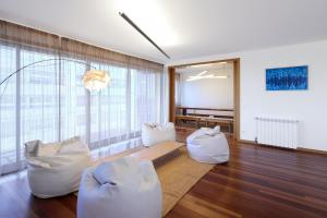 una sala de estar con muebles blancos y ventanas grandes. en HM - Ocean Breeze Delight, en Matosinhos
