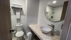 a bathroom with a toilet and a sink and a mirror at On Vacation Caribbean in San Andrés