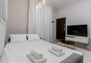 sypialnia z białym łóżkiem i ręcznikami w obiekcie Wrzesińska Luxury Apartment w Krakowie