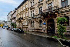 mokra ulica miejska z samochodami zaparkowanymi obok budynków w obiekcie Wrzesińska Luxury Apartment w Krakowie