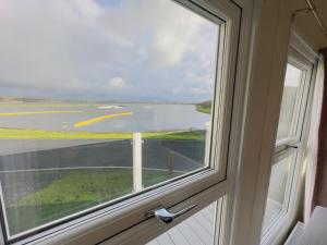 una ventana abierta con vistas a una pista de aterrizaje en LakeDistrict Caravan by Sleepy, en Millom