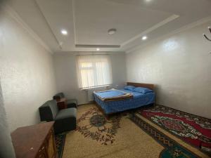 a room with a bed and a chair in it at Apartment Registan in Samarkand